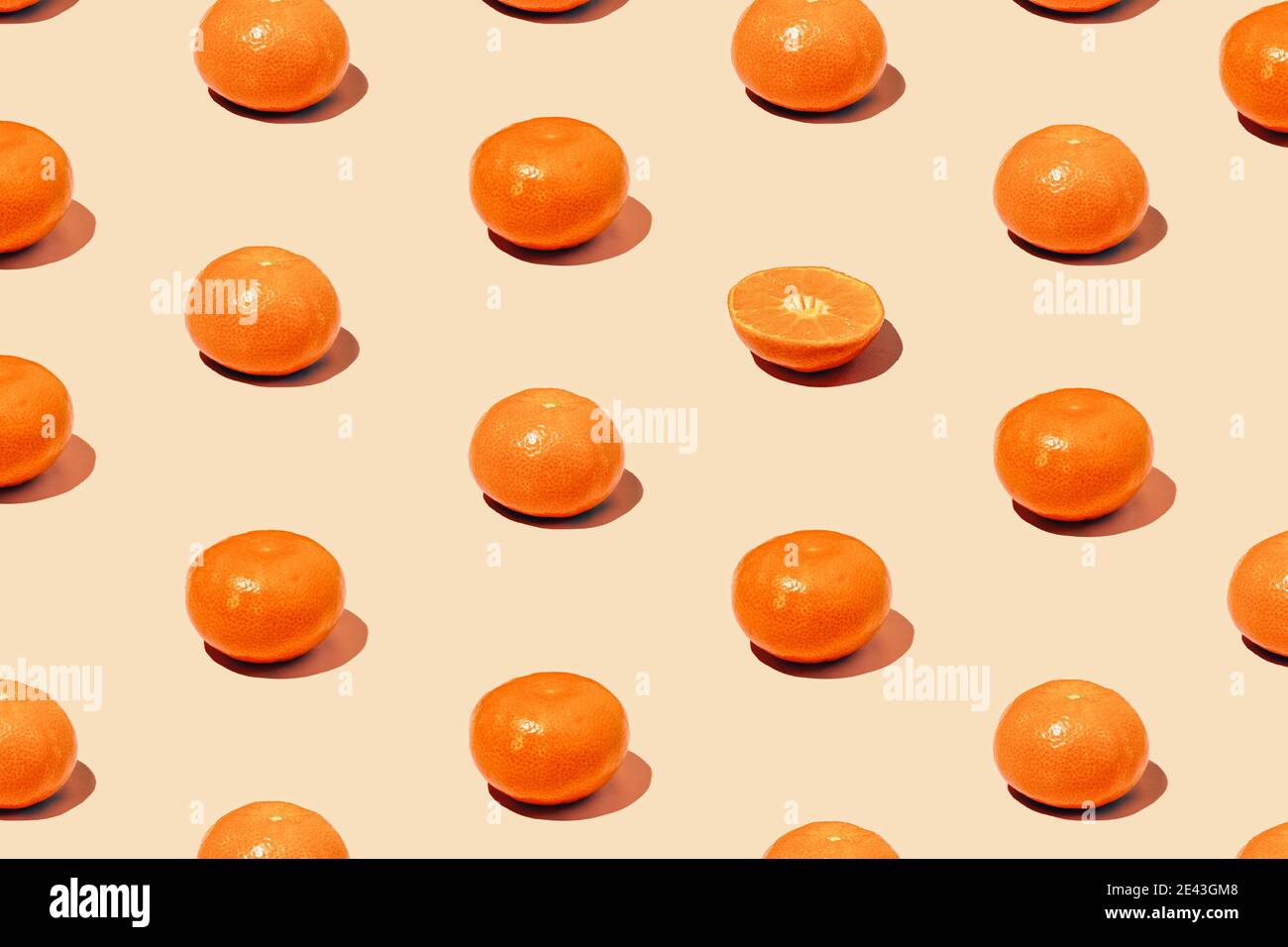 Disegno creativo monocromatico realizzato in tangerina fresca in diagonale. Agrumi succosi su sfondo Set Sail Champagne. Concetto minimo Foto Stock