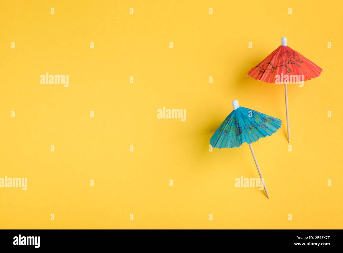 Gli ombrello blu e rosso si raccolse su sfondo giallo Foto Stock