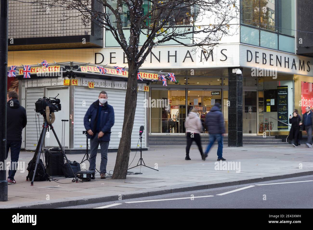 Media tv equipaggi in maschera di faccia stazionati fuori del grande magazzino Debenhams in Oxford Street, City of Westminster, Londra, Inghilterra, Regno Unito Foto Stock