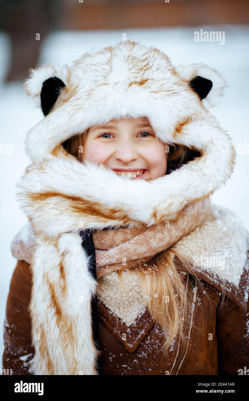 Ritratto di felice elegante bambino in un divertente cappello di pelliccia  con orecchie all'aperto nel parco della città in inverno Foto stock - Alamy