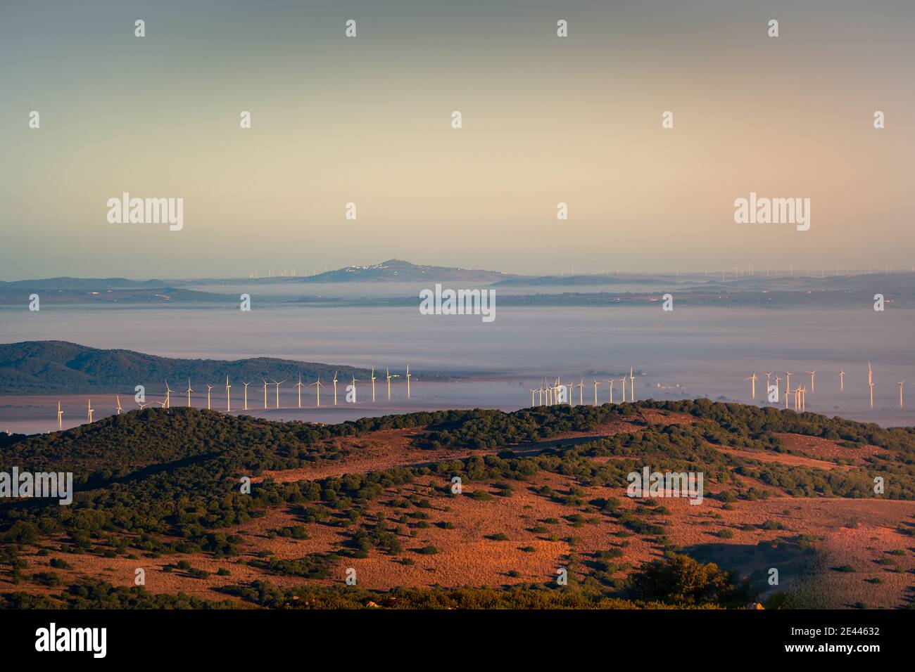 Turbine eoliche per l'energia alternativa situate nella valle circondata da Cresta di montagna frizzante vicino a Cadice città in Andalusia regione di Spagna Foto Stock