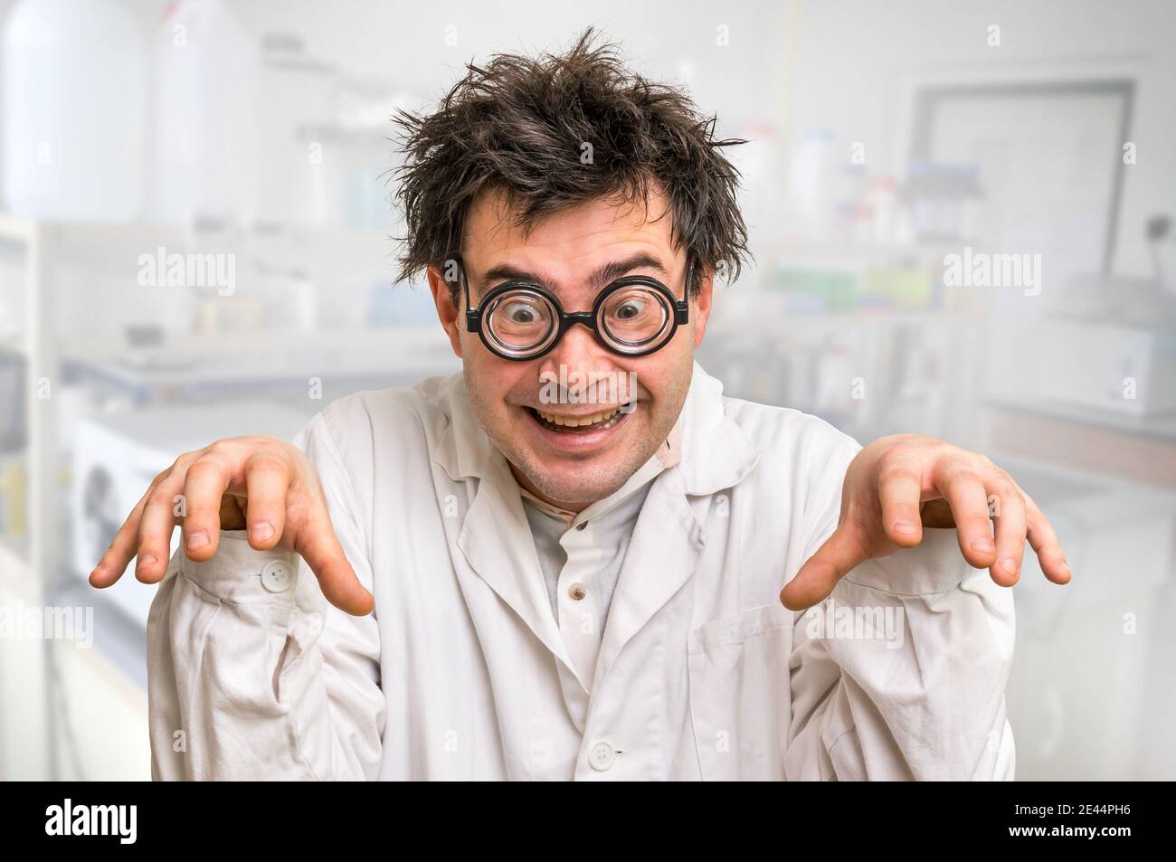 Scienziato divertente e pazzo con occhiali e cappotto bianco in laboratorio  Foto stock - Alamy