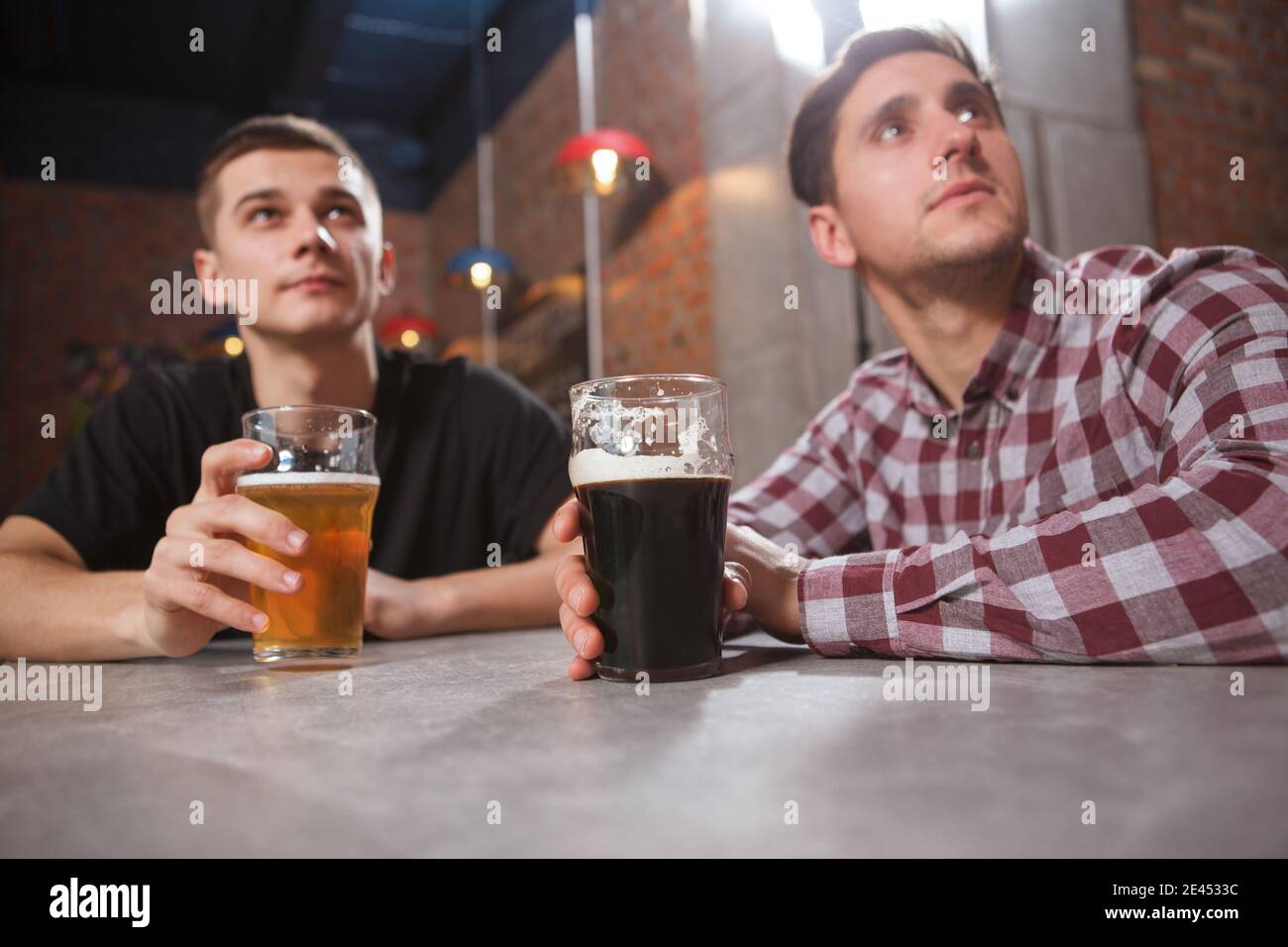 Due uomini che guardano la partita al pub della birra insieme Foto Stock