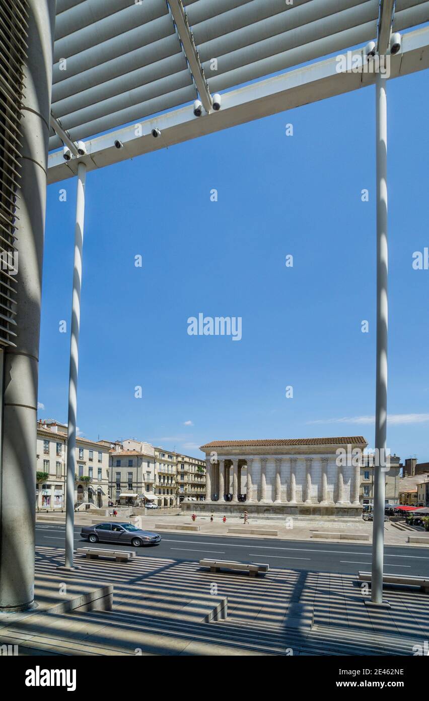 Maison Carrée, antico tempio romano a Nîmes visto dal futuristico museo d'arte contemporanea progettato da Norman Foster Carré d'Art, dipartimento del Gard, Occi Foto Stock