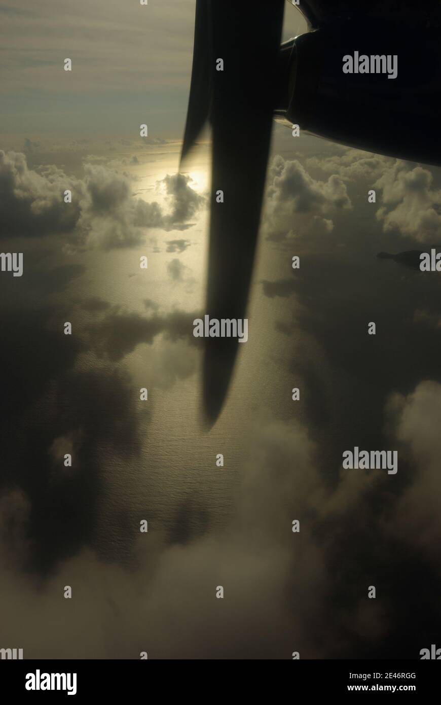 L'aereo propellerà l'ala contro un cielo nuvoloso e sull'oceano Foto Stock
