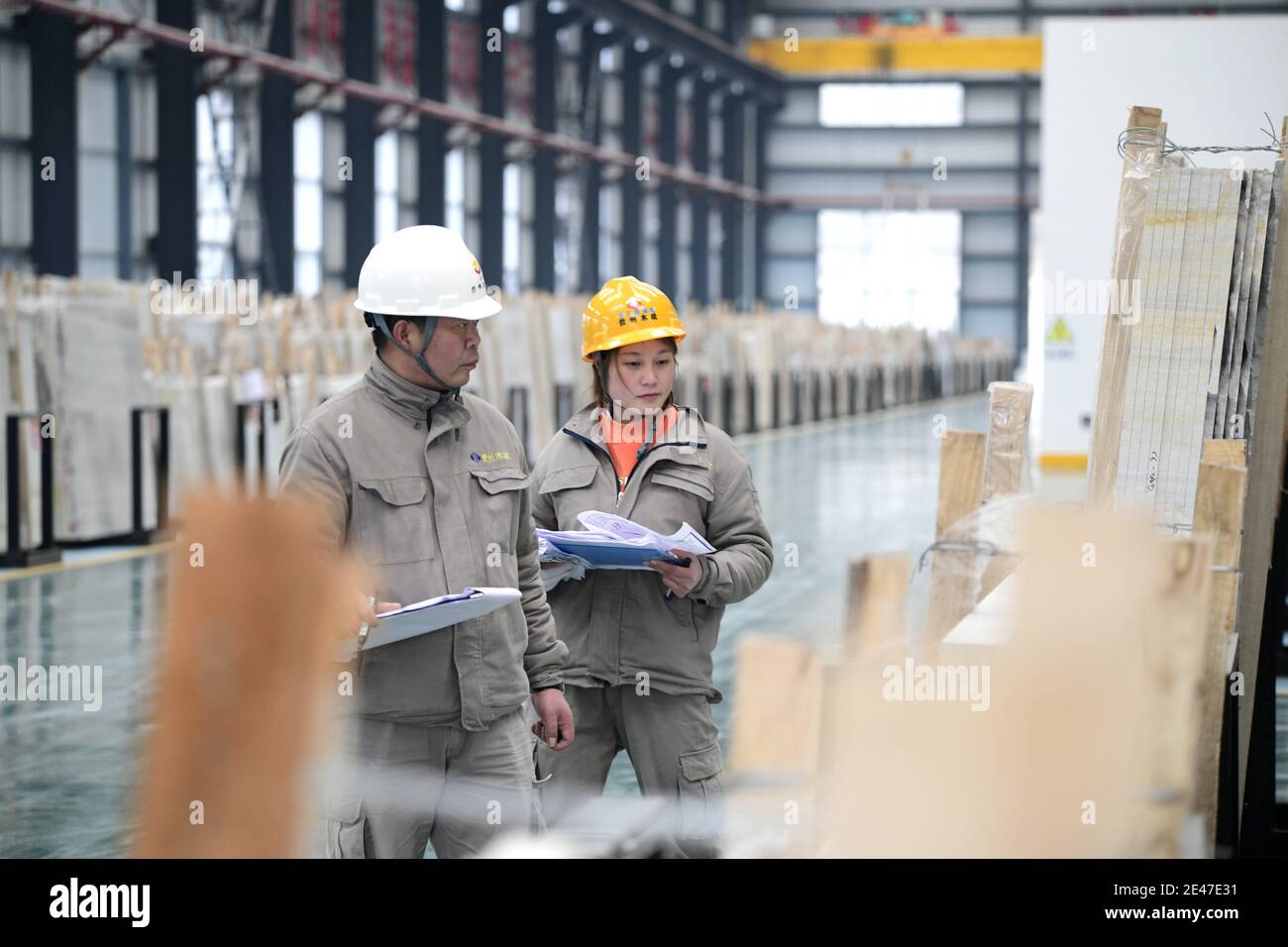 I lavoratori lavorano pietre in una fabbrica locale di pietra, Qianxinan Buyei e Prefettura Autonoma di Miao,¯nella provincia di Guizhou della Cina sudoccidentale, il 21 gennaio 2021. Foto Stock