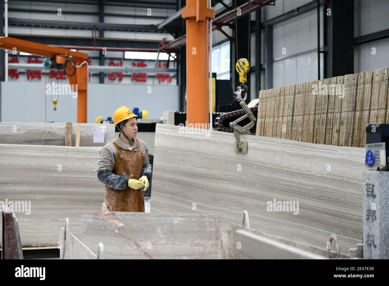 Un lavoratore lavora pietre in una fabbrica locale di pietra, Qianxinan Buyei e Prefettura Autonoma di Miao, nella provincia di Guizhou¯della Cina sudoccidentale, il 21 gennaio 202 Foto Stock