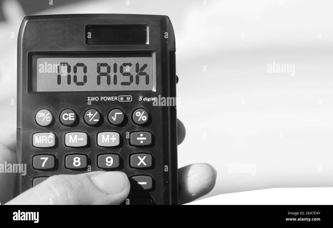 Parola Nessun rischio su tovagliolo e calcolatrice su toble di legno . Concetto finanziario. Foto Stock