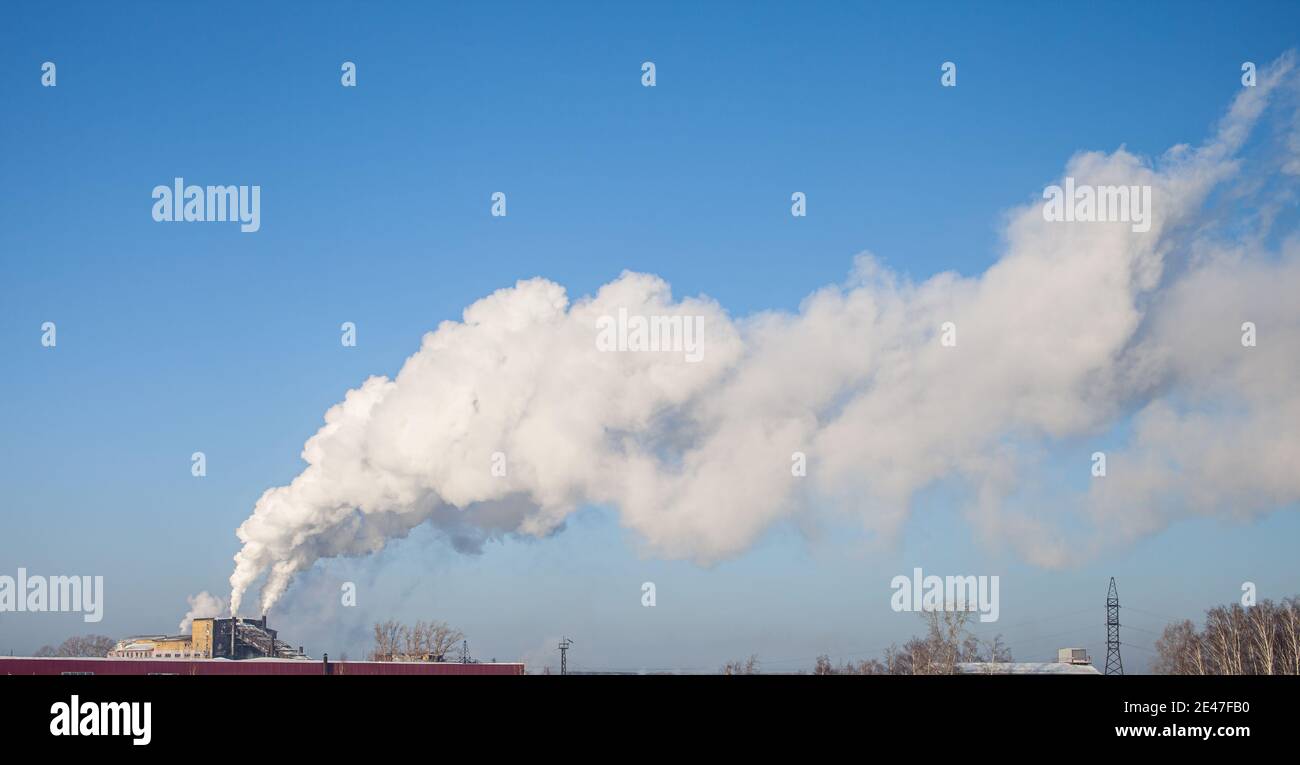 Fumo bianco spesso dal camino del locale caldaia. Fumo contro il cielo blu. Inquinamento atmosferico. Riscaldamento della città. Zona industriale. Foto Stock