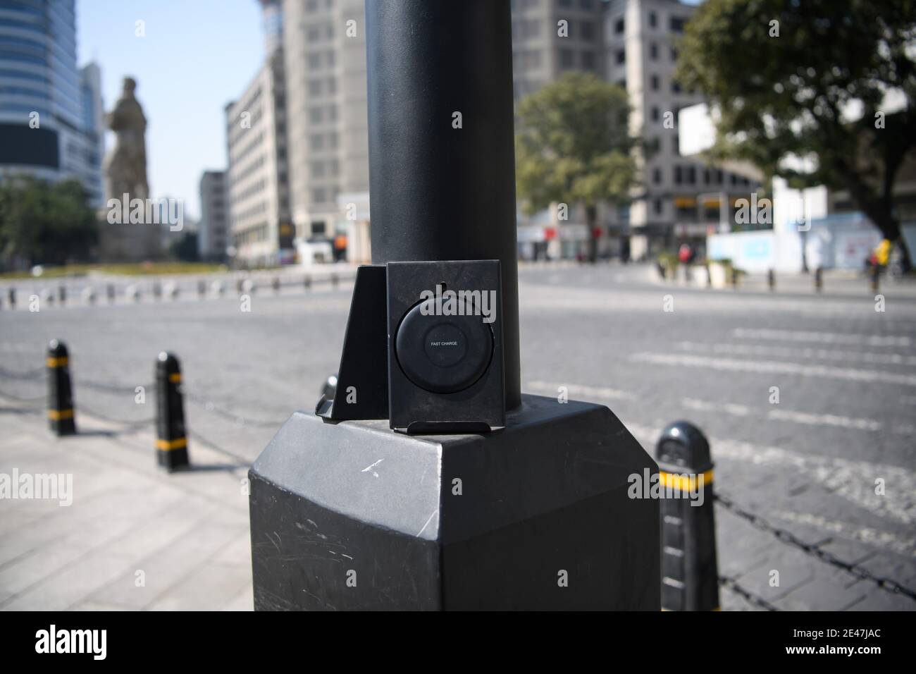 Un gadget fornisce la ricarica wireless per smartphone di pedoni sono visti attaccati ad una lampione nella città di Guangzhou, Cina meridionale¯s Guangdong provincia Foto Stock