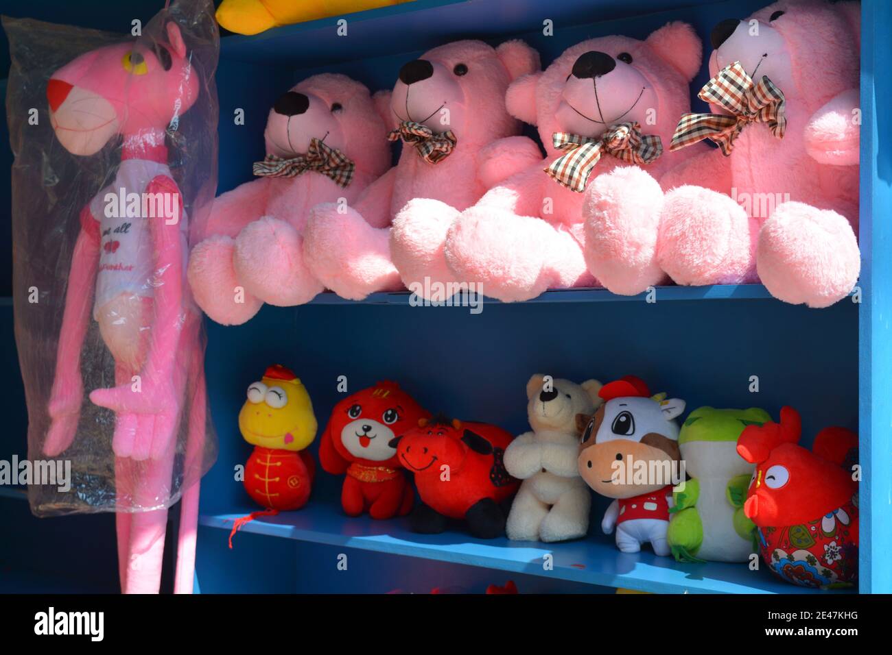 Giocattoli morbidi e colorati in un parco divertimenti cinese, premi per vari giochi. Tutti i tipi di animali rane, mucche, orsi, cani e pantera rosa Foto Stock