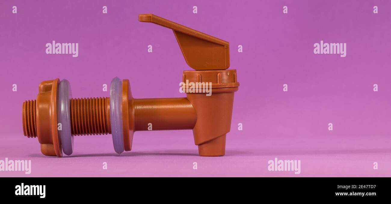 Primo piano di un rubinetto in plastica su sfondo viola Foto Stock