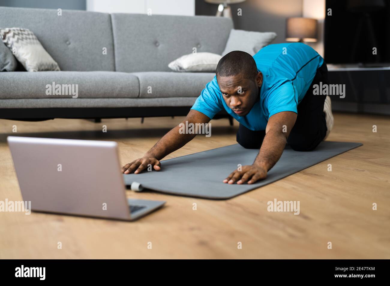 African American fare in linea che allunga la classe di workout di idoneità a casa Foto Stock