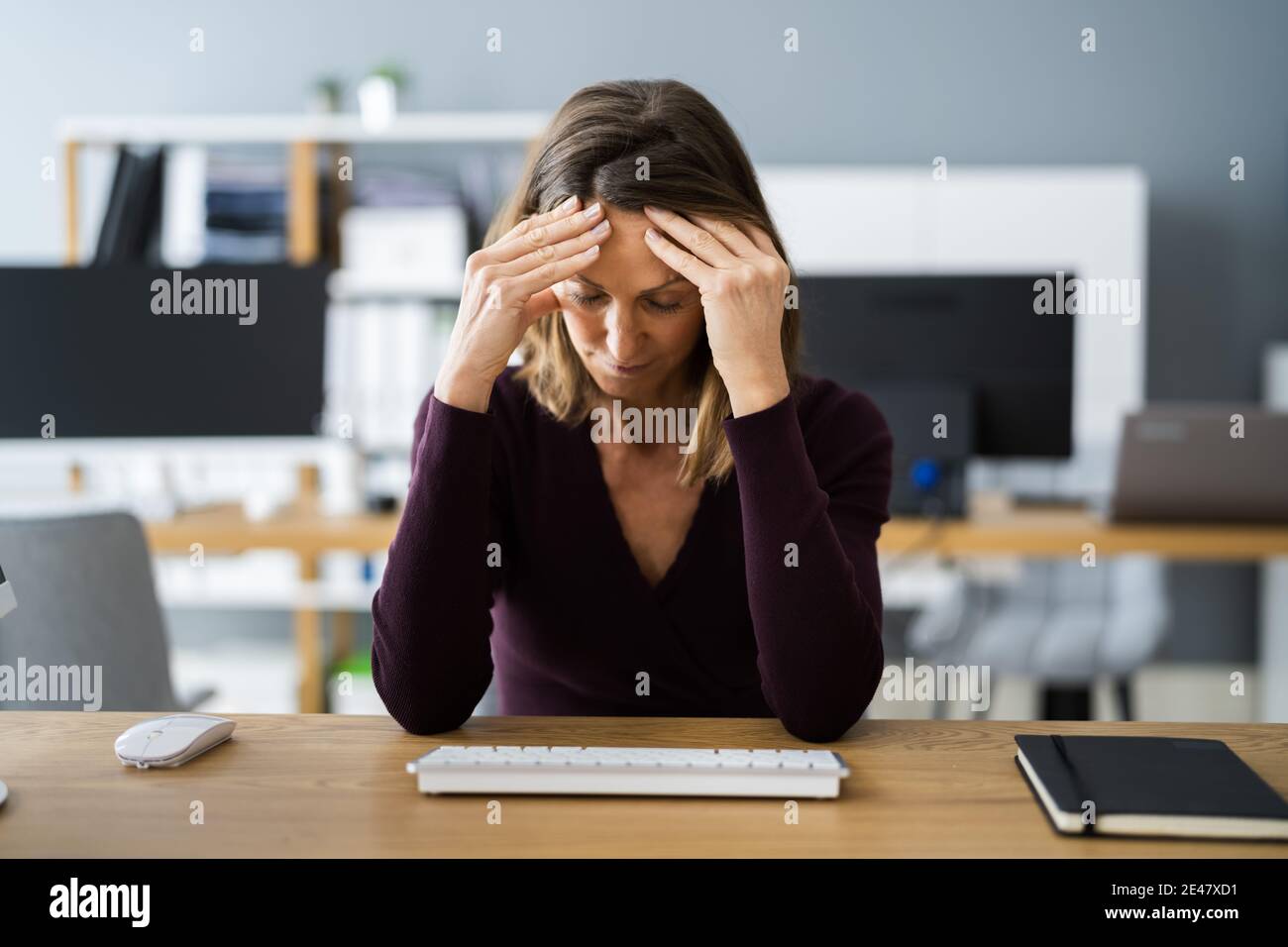 Donna casual con mal di testa in videoconferenza Foto Stock