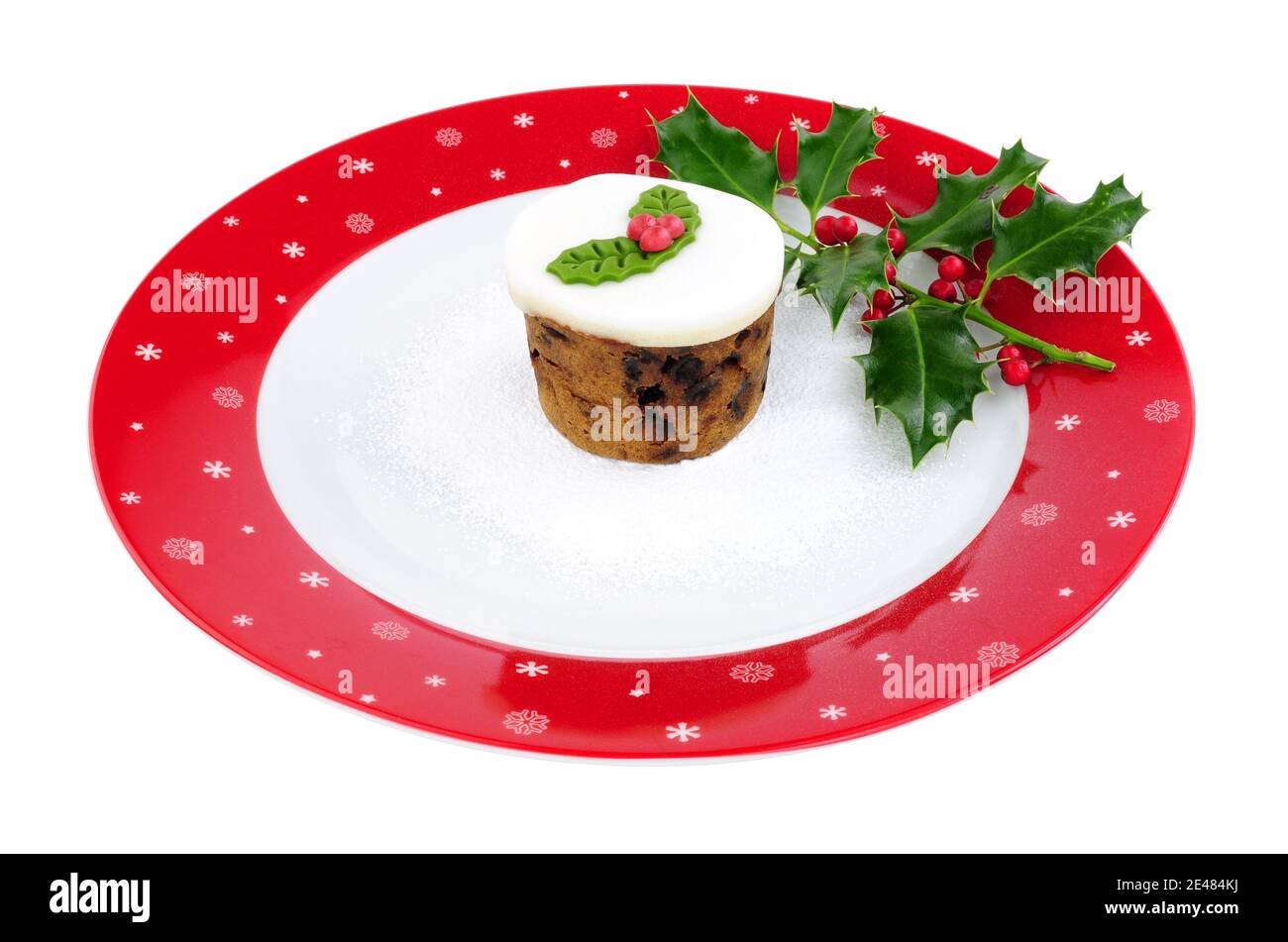 Mini torta di frutta di Natale su un grande piatto festoso decorato isolato su sfondo bianco Foto Stock