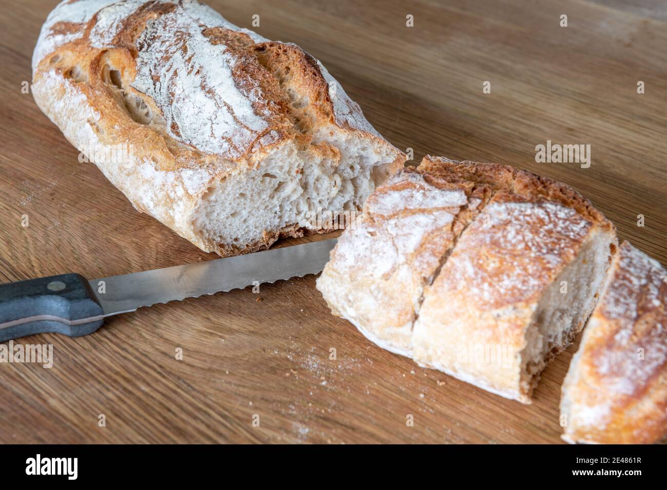 Pane francese tradizionale su tavola di legno con coltello Foto Stock