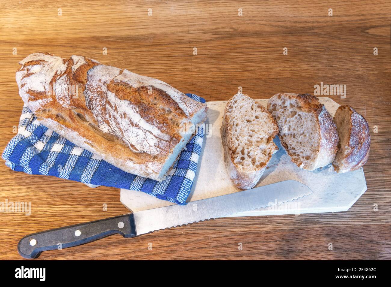 Pane francese tradizionale su tavola di legno con coltello Foto Stock