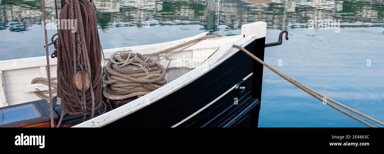Vista panoramica della prua di una piccola imbarcazione da pesca aperta con corda di ormeggio a spirale Foto Stock