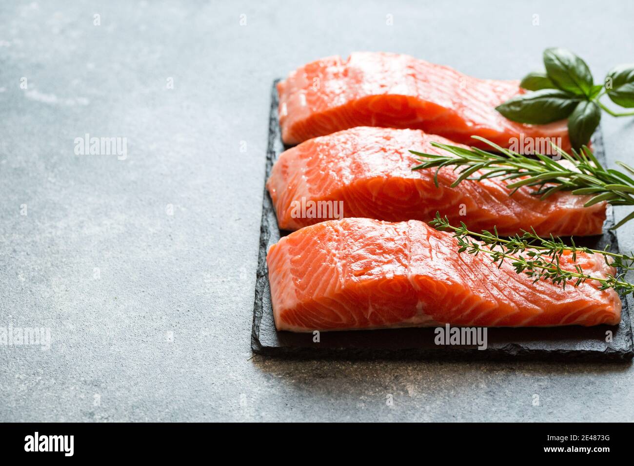 Salmone. Filetto di salmone fresco crudo con ingredienti da cucina, erbe e limone. Primo piano. Cibo sano, dieta o concetto di cucina Foto Stock