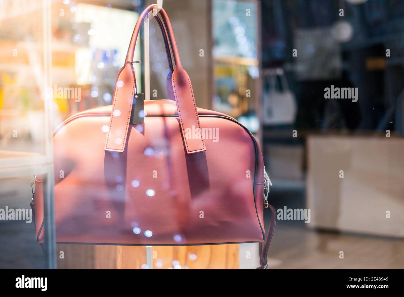 borsa donna sulla vetrina del negozio con luce bokeh e. nessun background di persone Foto Stock