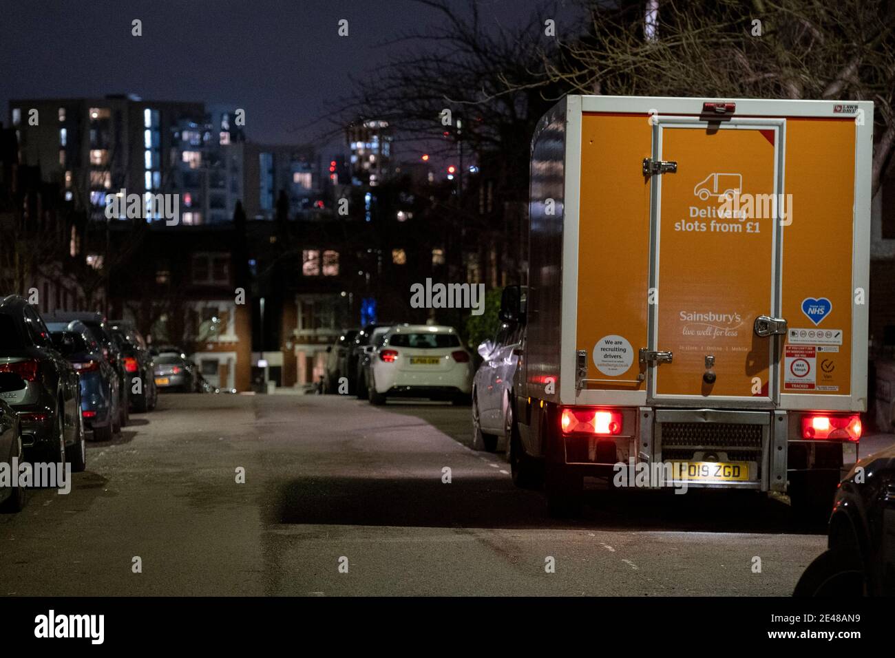 Un furgone di consegna di Sainsbury effettua il rientro di un ordine di acquisto online per i clienti che vivono in una strada residenziale buia a Herne Hill, a sud di Londra, il 21 gennaio 2021, a Londra, Inghilterra. Foto Stock