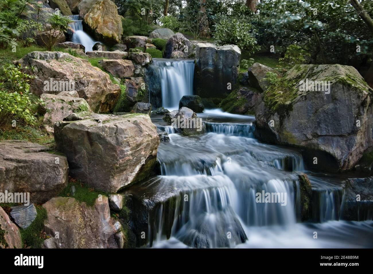 Lunga esposizione cascata liscia e setosa su scogliere rocciose nel Giardino di Kyoto, Holland Park Foto Stock