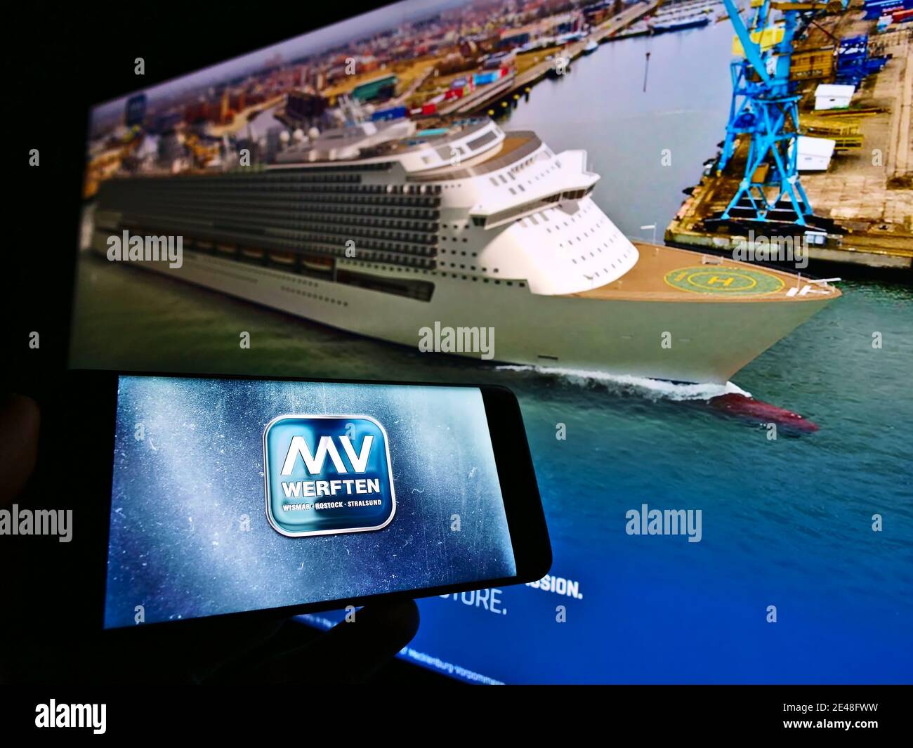 Persona che detiene il telefono cellulare con il logo della società tedesca di costruzione navale MV Werften di fronte al sito web aziendale. Mettere a fuoco il centro dello schermo del telefono. Foto Stock