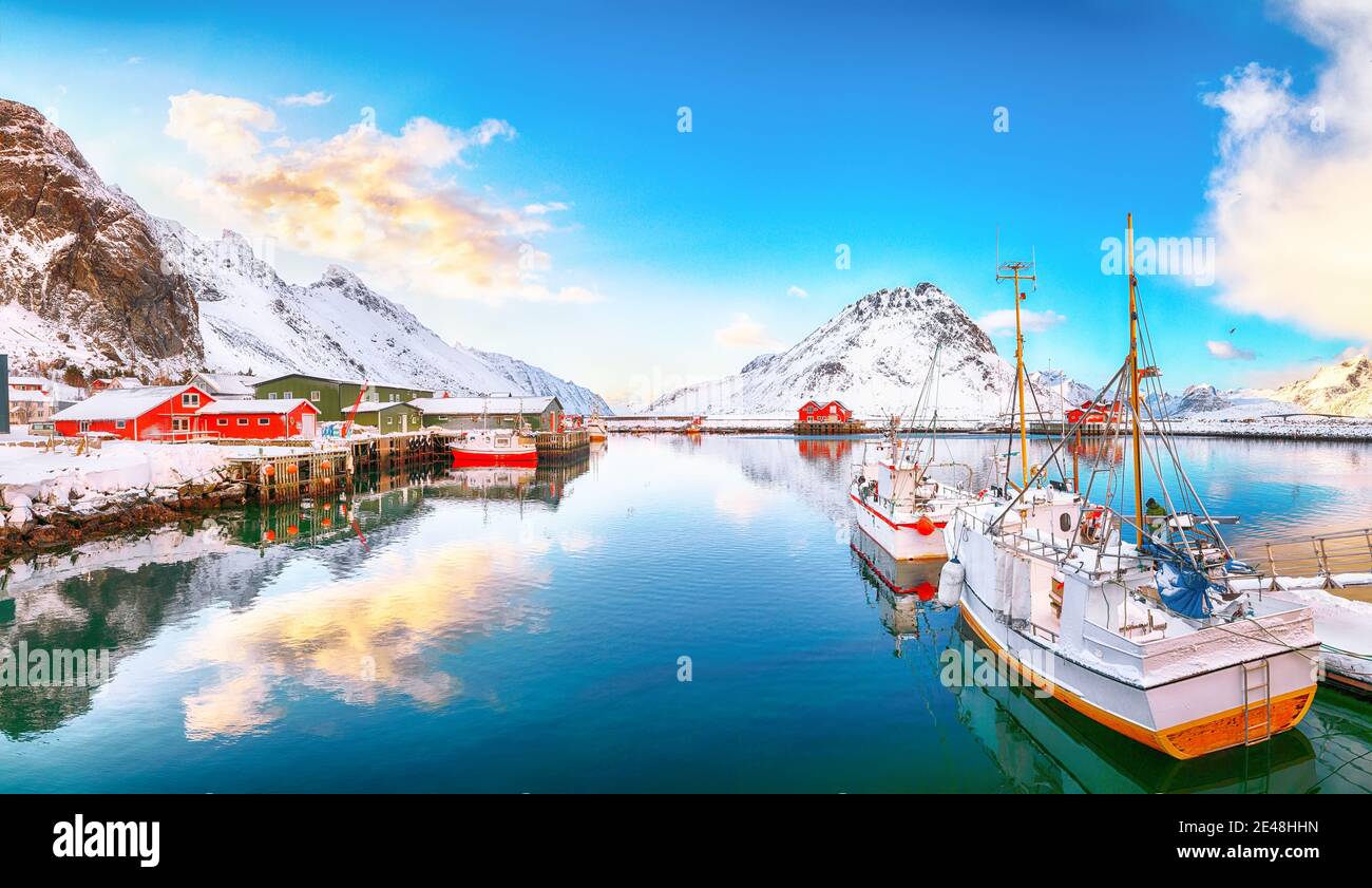 Incredibile alba invernale sul villaggio e il porto di Ramberg. Ormeggiate navi da pesca nel porto. Ubicazione: Ramberg, isola di Flakstadoya, Lofoten; Norvegia, Europa Foto Stock