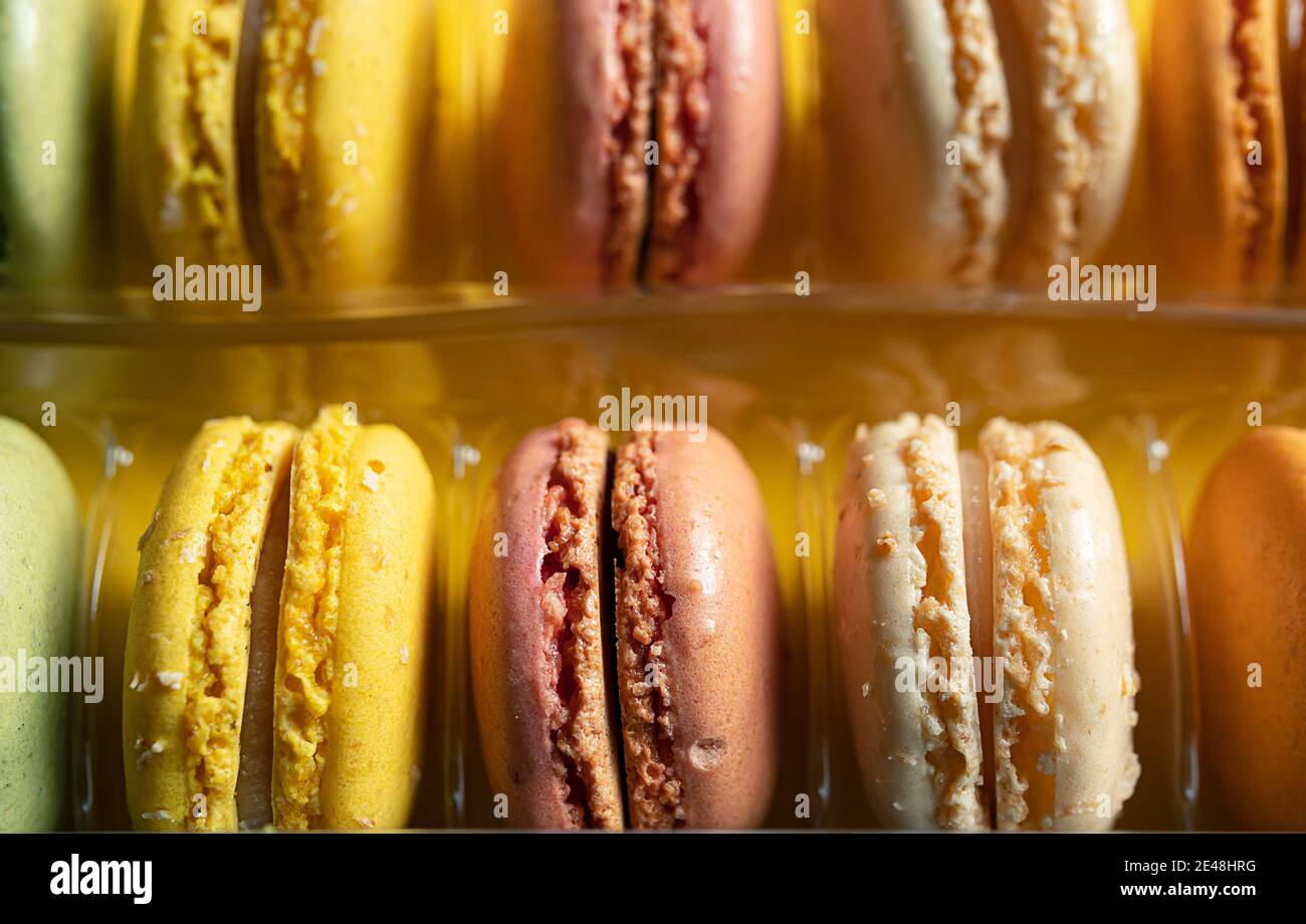 Set di maccheroni tradizionali francesi in confezione trasparente su sfondo giallo, primo piano di messa a fuoco selettiva Foto Stock
