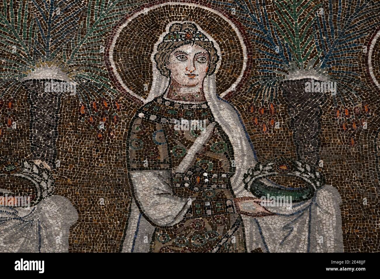 La Santa cristiana, gioiellata e vestita sontuosamente, cammina in processione. Mosaico bizantino nella Basilica di Sant'Apollinare nuovo a Ravenna, Emilia-Romagna, Italia. Il mosaico fu creato nel 500 d.C., pochi anni dopo che Ravenna fu catturata dall'Impero bizantino dagli Ostrogoti. Foto Stock