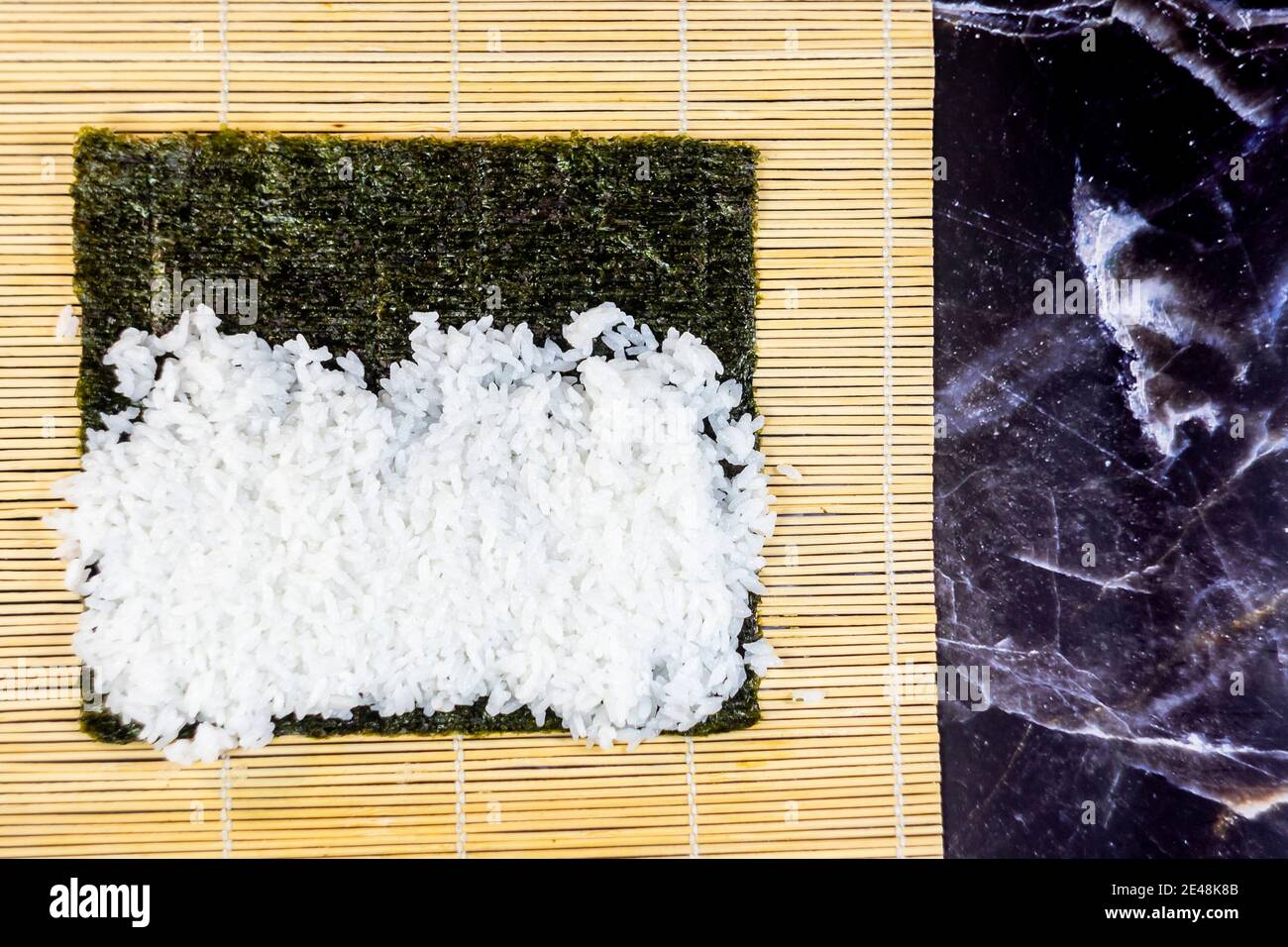 sushi fatto in casa tradizionale giapponese maestro di fare sani panini maki con gamberi cetrioli carote pesce Foto Stock