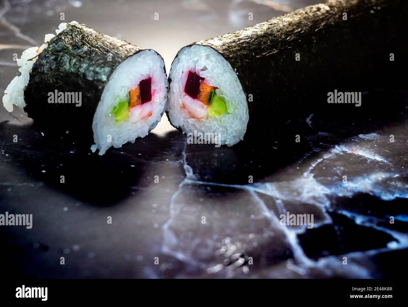 sushi fatto in casa tradizionale giapponese maestro di fare sani panini maki con gamberi cetrioli carote pesce Foto Stock