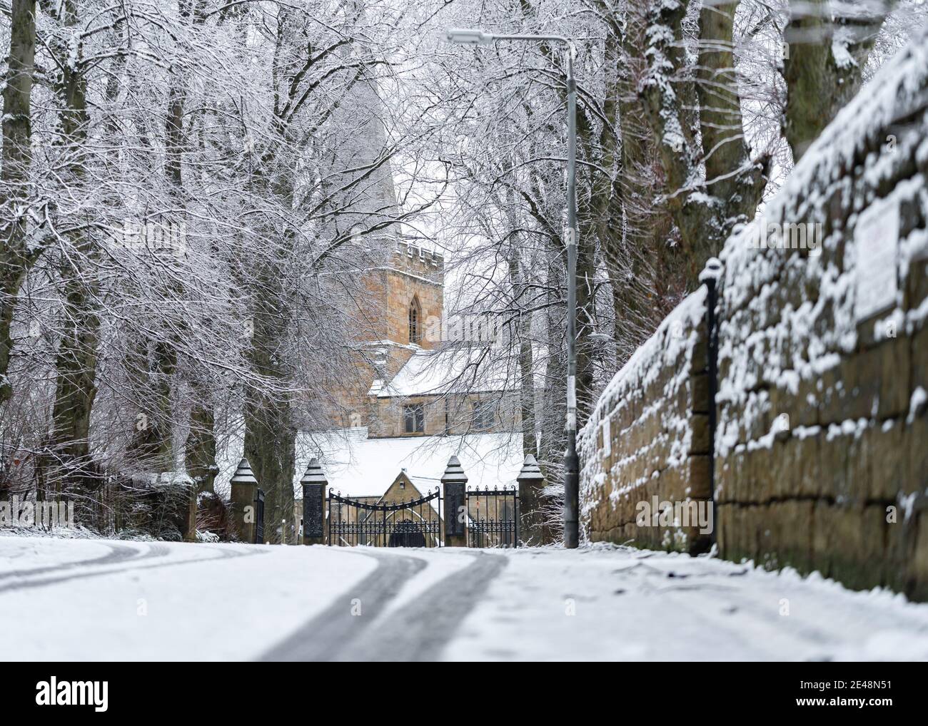 Inverno una bella scena di chiesa di villaggio con la neve profonda caduta sul tetto e vialetto nevoso si stabilì con alberi di pietra Muro in città Sutton in Ashfield Foto Stock