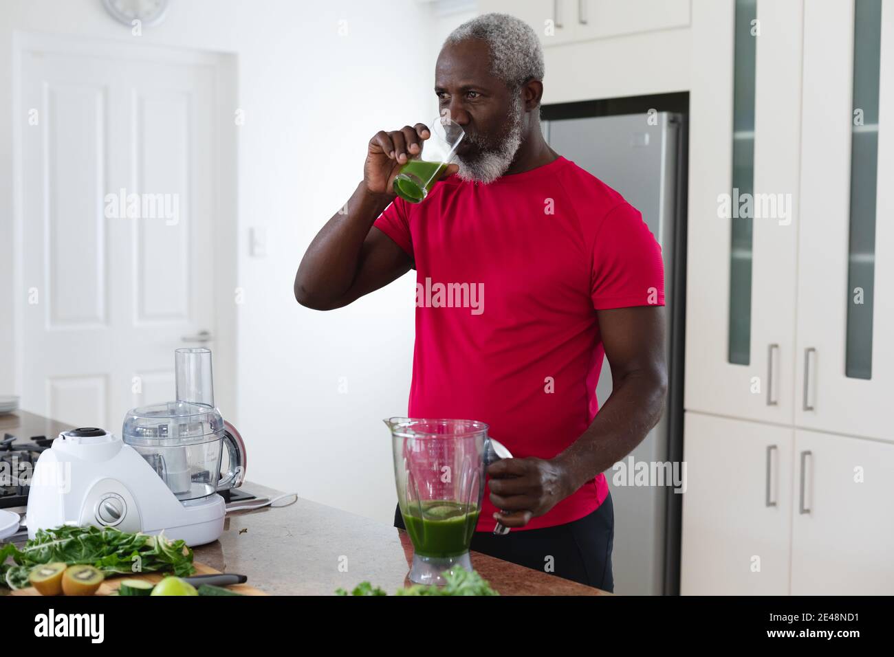 Uomo africano americano anziano che beve frutta e verdura bevanda di salute Foto Stock