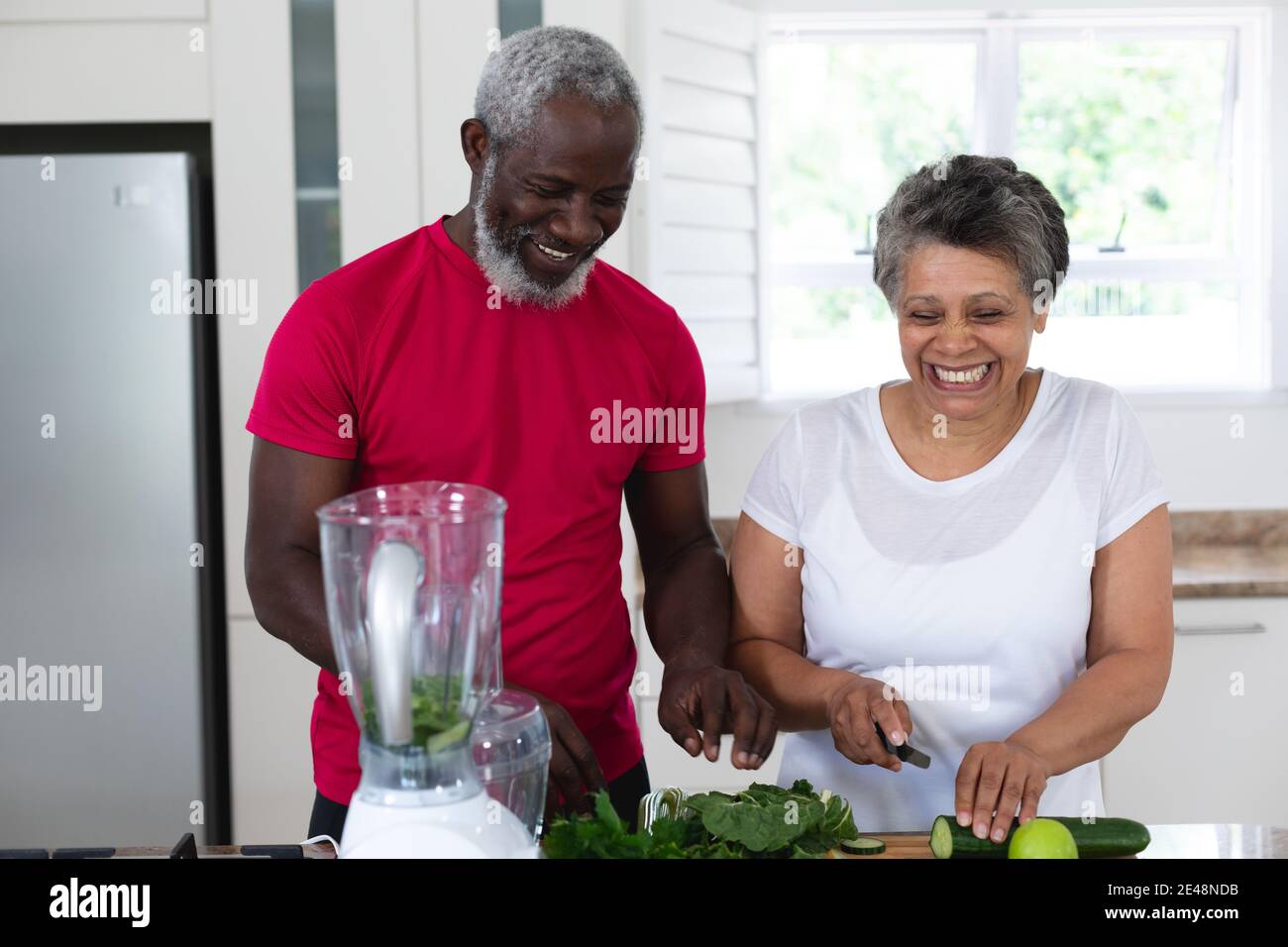 Uomo e donna afro-americana senior che prepara frutta e verdura bevande salutari Foto Stock