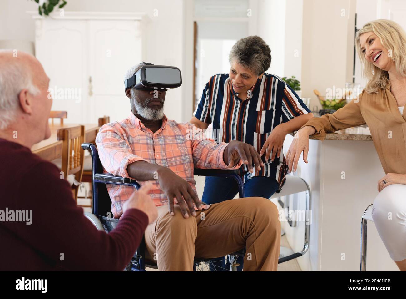 Coppie caucasiche e afroamericane senior seduti sul divano utilizzando visore vr a casa Foto Stock