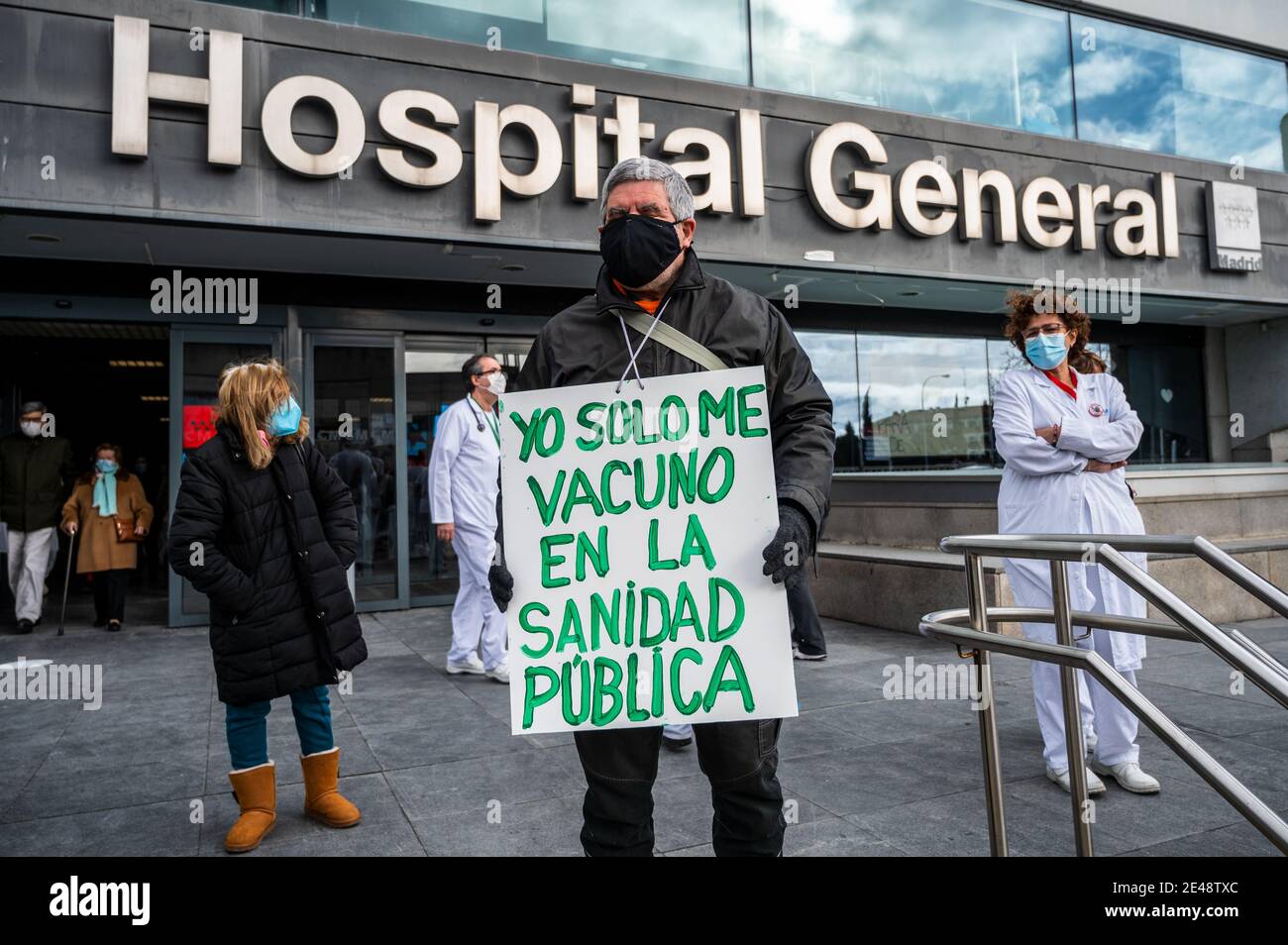 Madrid, Spagna. 22 gennaio 2021. Un uomo con un cartello che recita "sono vaccinato solo in salute pubblica" protestando all'ospedale la Paz durante una manifestazione contro i trasferimenti forzati di personale sanitario al nuovo ospedale di emergenza Isabel Zendal. Manifestanti protestano contro la gestione della crisi del coronavirus (COVID-19) da parte del presidente regionale di Madrid Isabel Diaz Ayuso. Credit: Marcos del Mazo/Alamy Live News Foto Stock