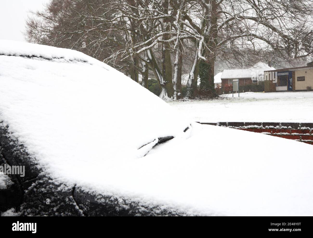 Un parabrezza e un cofano per auto coperti in una notte di nevicate in una zona residenziale di Hellesdon, Norfolk, Inghilterra, Regno Unito. Foto Stock