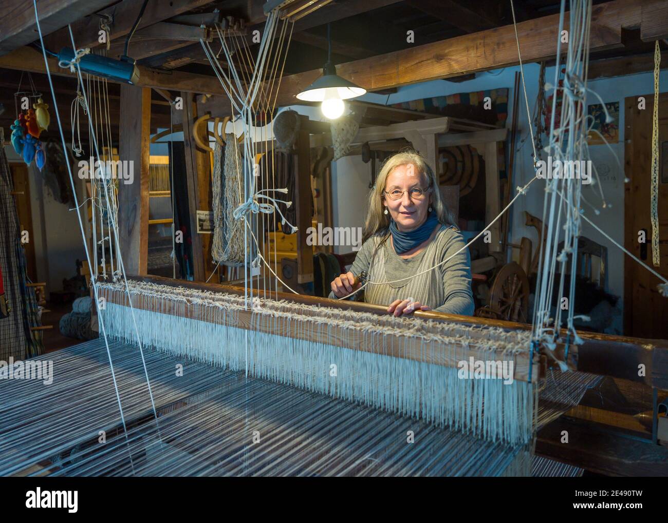 Batzlow, Germania. 07 gennaio 2021. Costanze Büxler, proprietario di Urticahof, lavora in un telaio. Al centro di Märkische Schweiz, i tappeti e i tessuti sono realizzati secondo le specifiche del cliente sui telai a mano. Nei corsi i visitatori possono imparare l'feltraggio, la filatura o la tintura con materiali naturali. Le vecchie tecniche artigianali sono affascinanti, ma non sono più redditizie. Credit: Patrick Pleul/dpa-Zentralbild/ZB/dpa/Alamy Live News Foto Stock