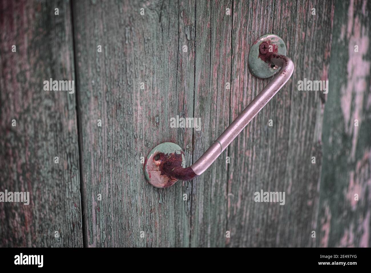 Un vecchio pomolo arrugginito su una porta di legno. Primo piano. Foto Stock