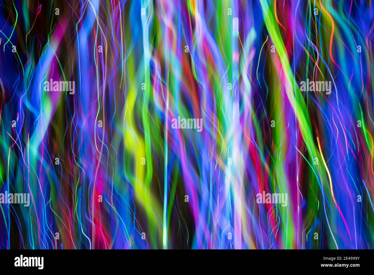 Effetto astratto di forme dinamiche multicolore in spessore variabile creato da luci a LED fotografate all'aperto di notte. Foto Stock