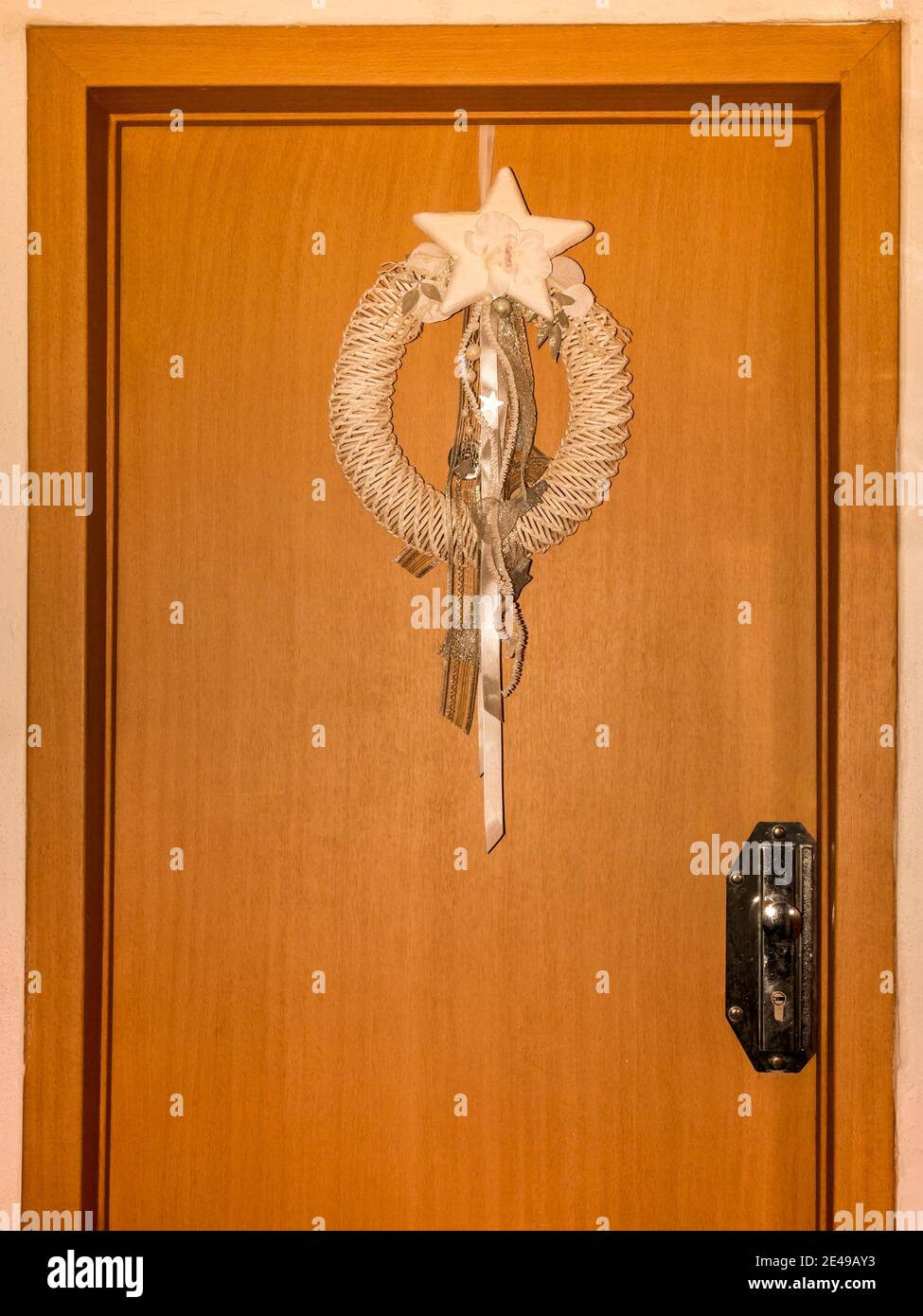 Corona di Natale appesa su una porta di legno. Foto Stock