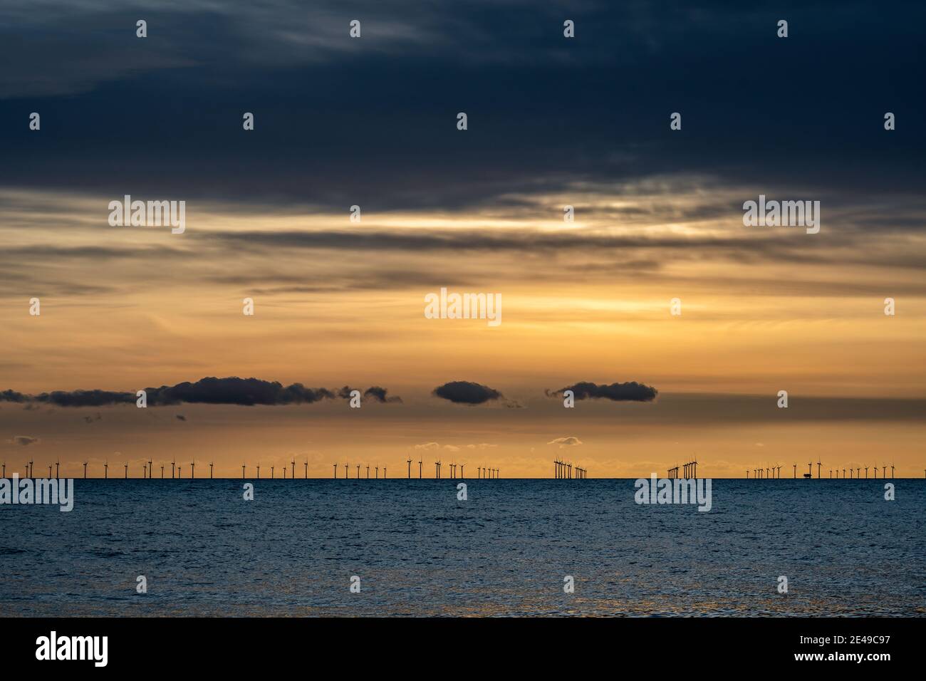 Energie rinnovabili al largo della costa al tramonto Foto Stock