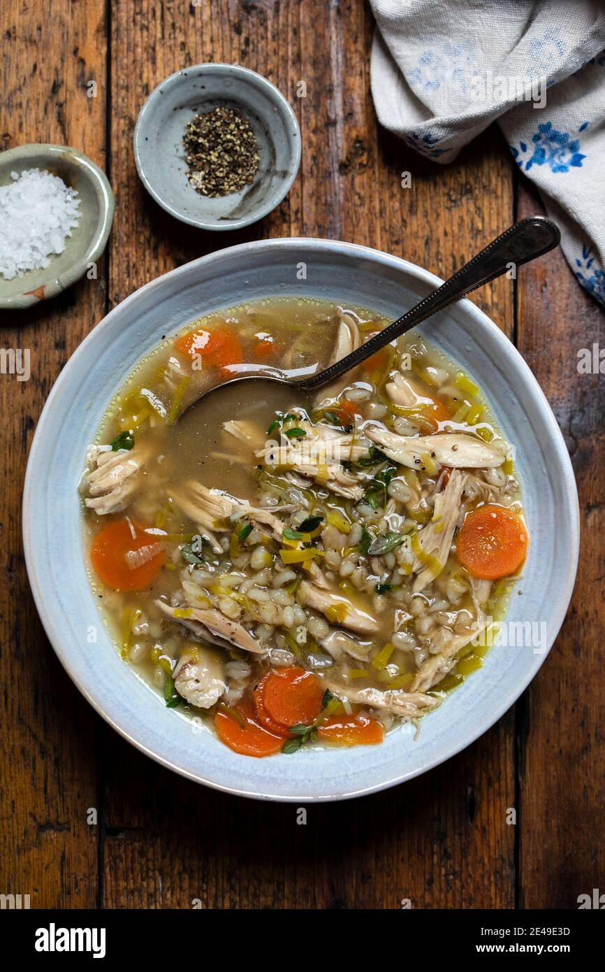 Zuppa invernale confortevole con pollo, orzo perlato e verdure Foto Stock