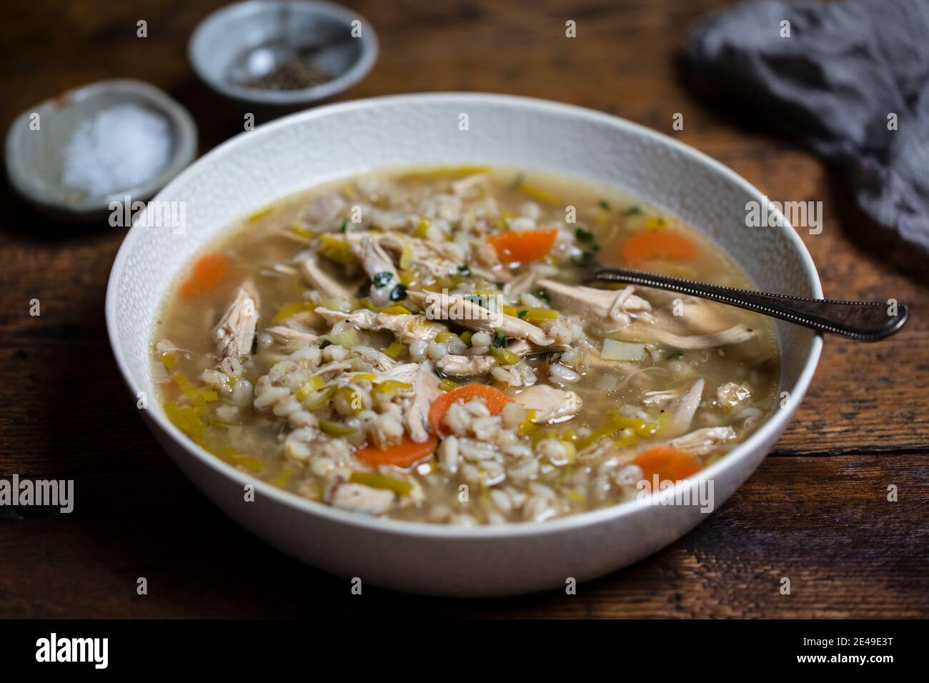 Zuppa invernale confortevole con pollo, orzo perlato e verdure Foto Stock