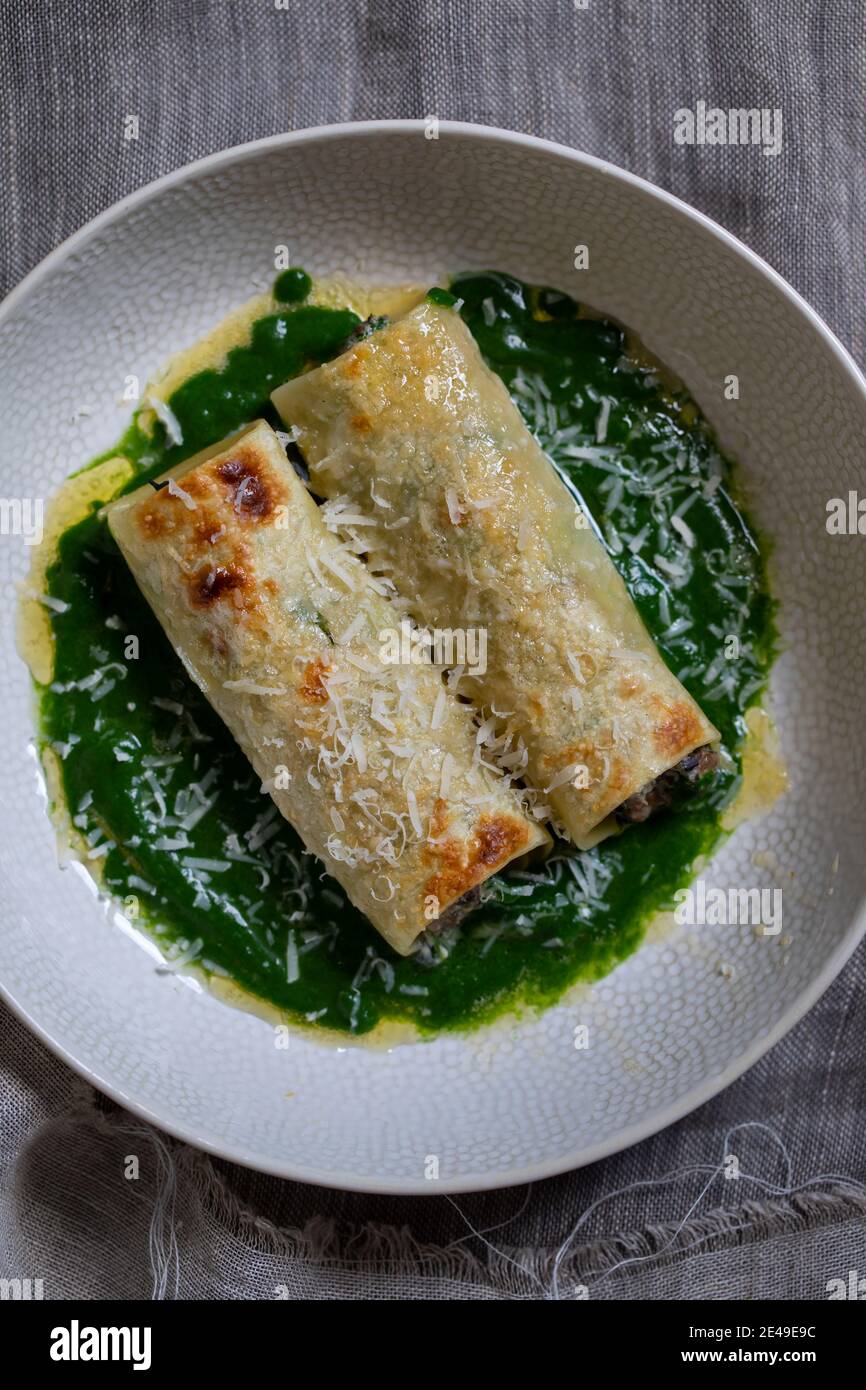 Funghi, spinaci e ricotta chesse cannelloni in salsa di spinaci Foto Stock