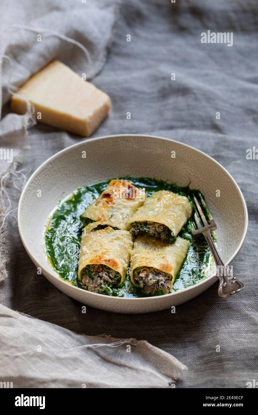 Funghi, spinaci e ricotta chesse cannelloni in salsa di spinaci Foto Stock