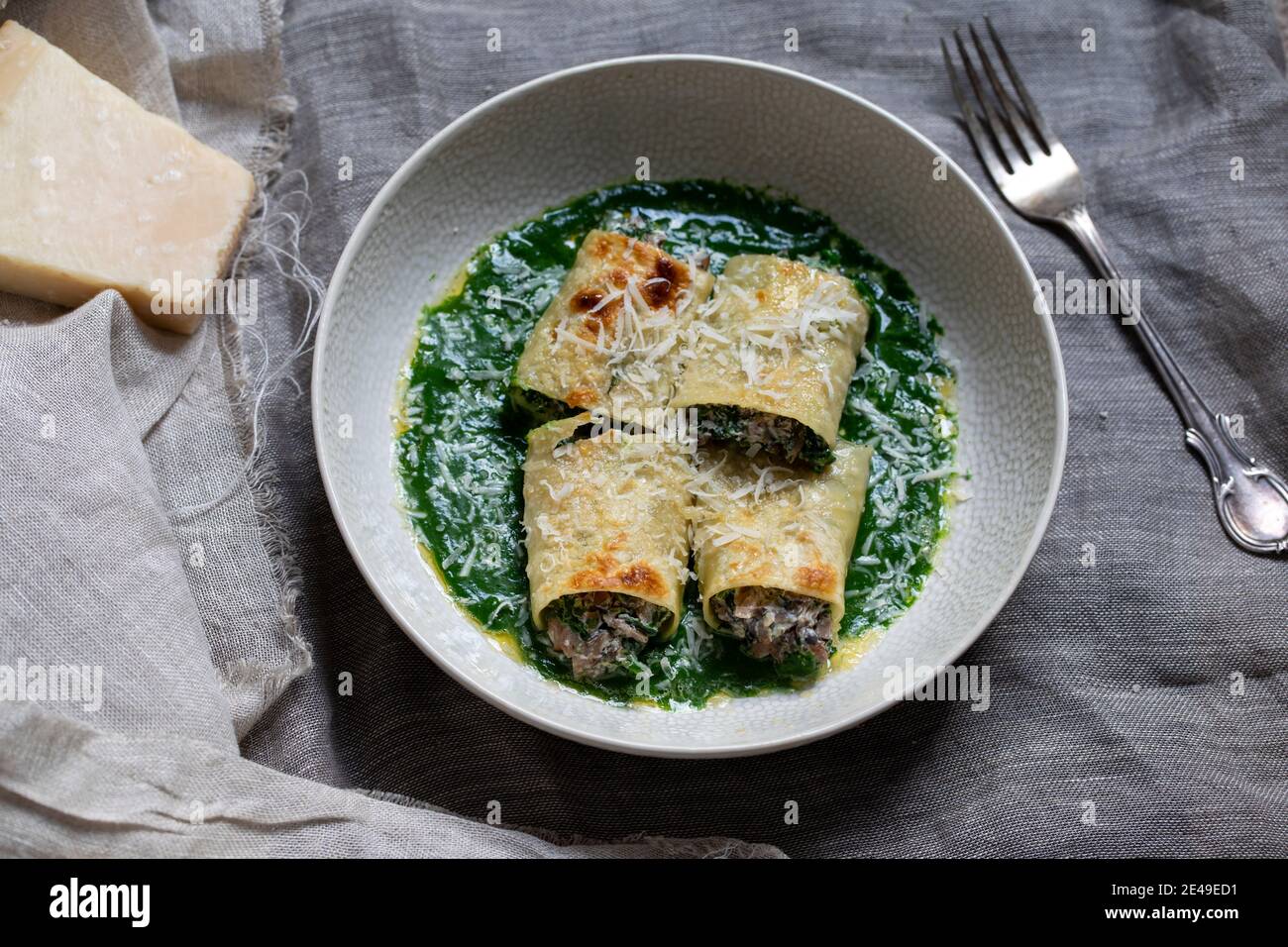 Funghi, spinaci e ricotta chesse cannelloni in salsa di spinaci Foto Stock