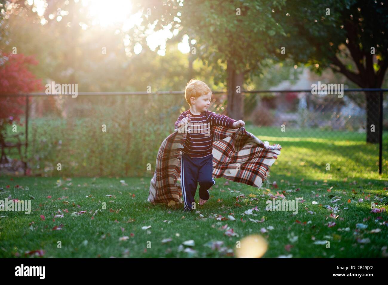 Ragazzo 3-4 anni cortile running con coperta in bella leggero Foto Stock