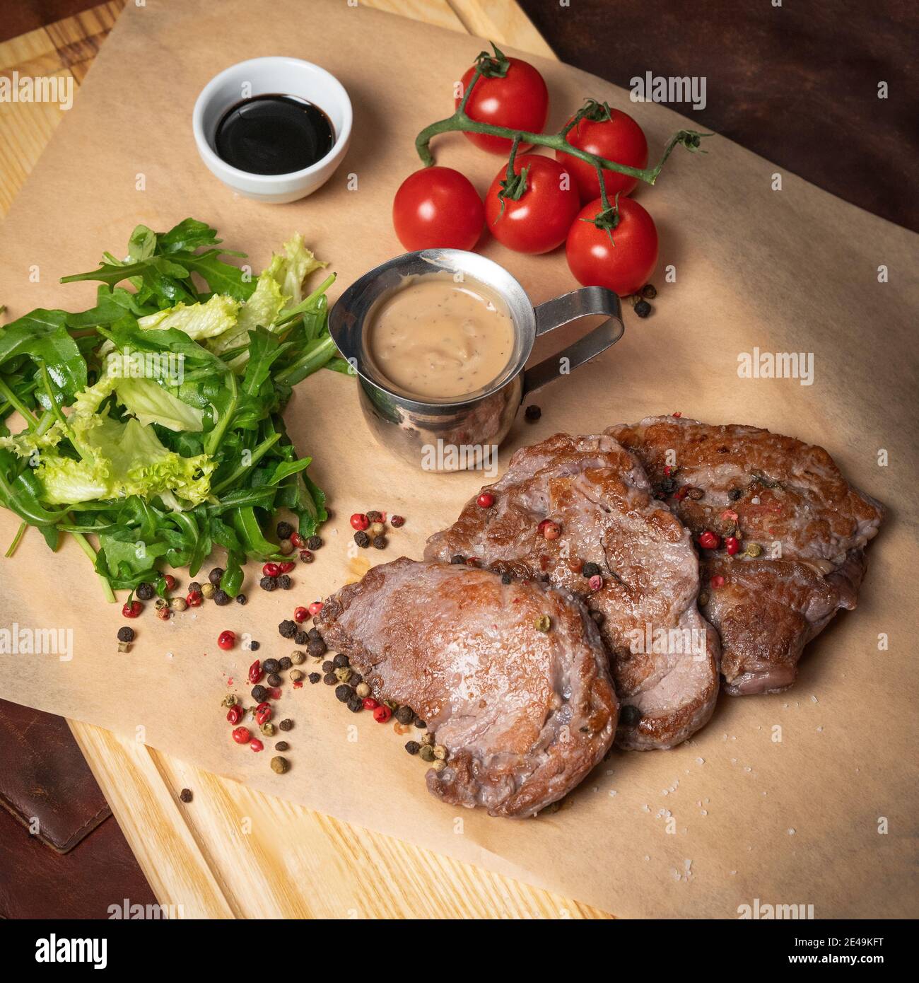 Filetti di maiale freschi serviti con insalata di lattuga con miscela di peperoni semi di rucola e pomodori ciliegini. Concetto di ristorante. Ristorante cibo. Griglia Foto Stock